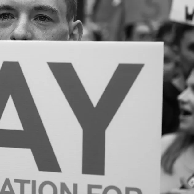 A demonstrator holds a placard during a protest calling for better pay for Junior Doctors in Whitehall, outside the gates of Downing Street in central London on August 11, 2023