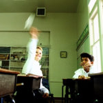Schoolboy misbehaving in class