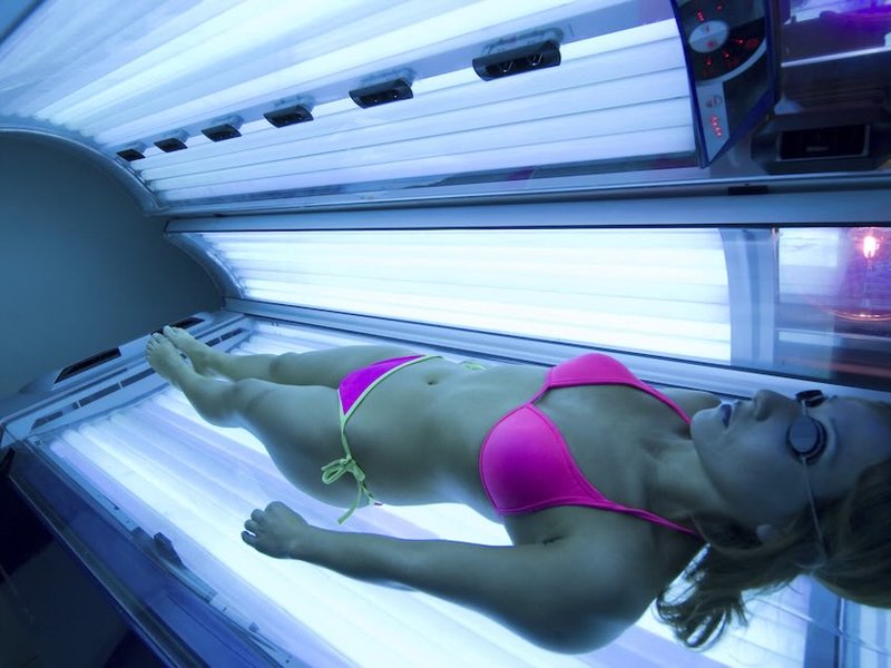 A woman lies on a sunbed