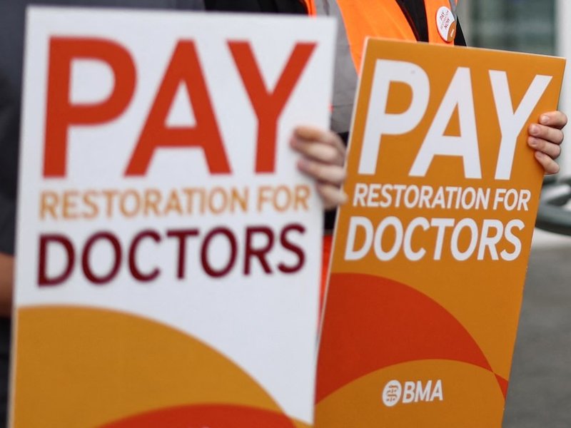 Placards calling for better pay for junior doctors on a picket line outside University College Hospital in London in 2023.