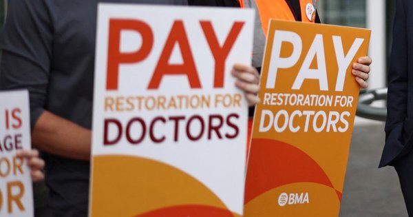 Placards calling for better pay for junior doctors on a picket line outside University College Hospital in London in 2023.