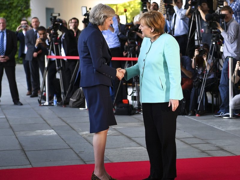 Theresa May and Angela Merkel shaking hands