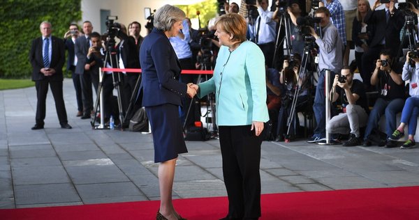 Theresa May and Angela Merkel shaking hands
