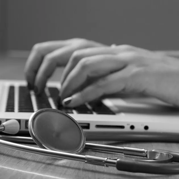 A doctor working on their laptop