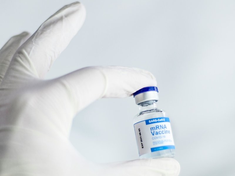 gloved hand holding a vaccine vial