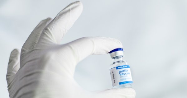 gloved hand holding a vaccine vial