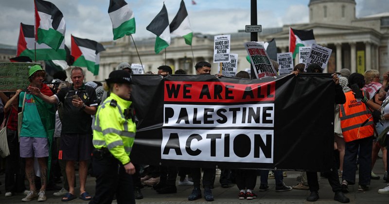 Police officers monitor protesters holding a banner in support of pro-Palestinian group Palestine Action in London this week.