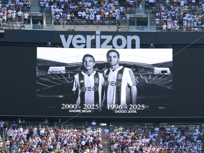 A black and white photo of brothers Diogo Jota and Andre Silva displayed on a screen in a football stadium.