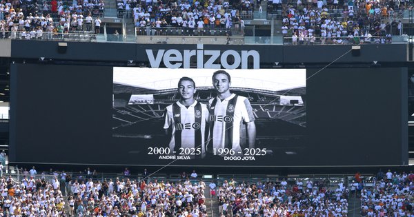 A black and white photo of brothers Diogo Jota and Andre Silva displayed on a screen in a football stadium.