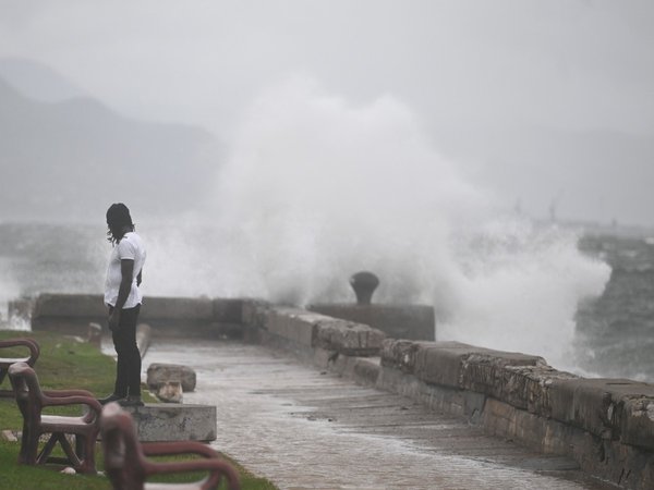 A man watches the waves crash into the walls at the Kingston Waterfront on October 27, 2025.