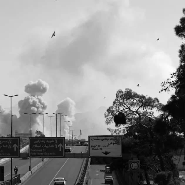 Vehicles drive along an expressway against the backdrop of smoke rising after a strike on the Iranian capital of Tehran on March 5, 2026.