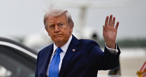 US President Donald Trump waves after stepping off Air Force One at Joint Base Andrews upon returning from Florida on 25 April 2026.