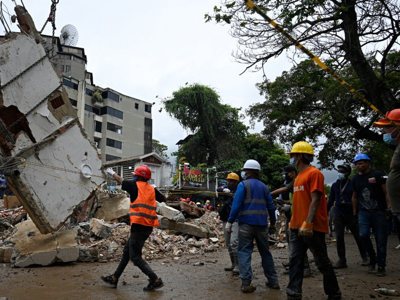 Workers remove debris from a collapsed building in the San Bernardino neighborhood of Caracas on 28 June, 2026, following earthquakes.