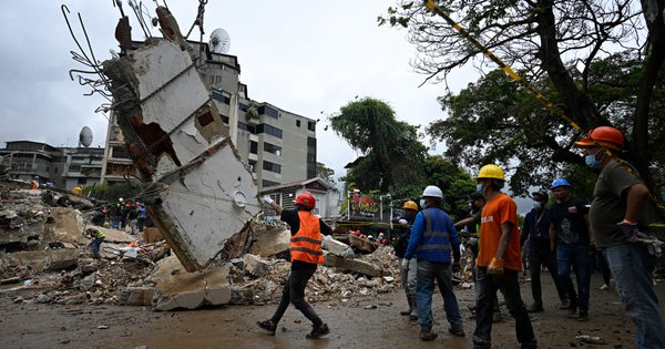 Workers remove debris from a collapsed building in the San Bernardino neighborhood of Caracas on 28 June, 2026, following earthquakes.