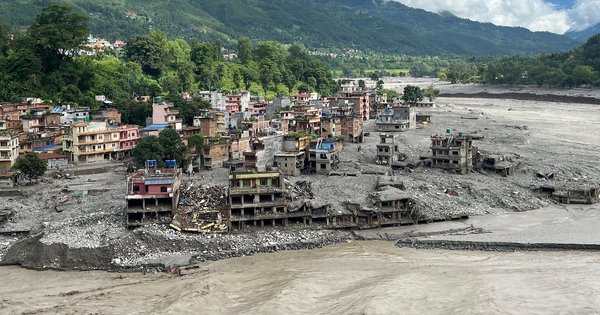 An aerial view shows a torrent of muddy water surging past houses and through the Trishuli River in the aftermath of flash floods at Trishuli Center in Nepal's Nuwakot district on September 1, 2026.