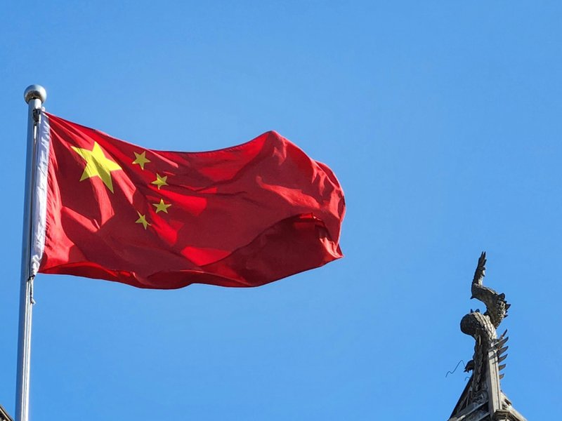 A Chinese flag flying on a flagpole.