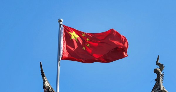 A Chinese flag flying on a flagpole.