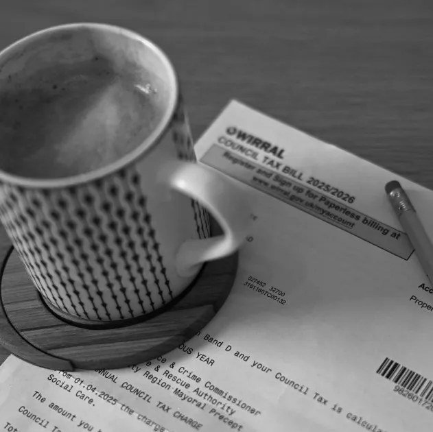 A council tax bill on a table next to a cup of coffee.