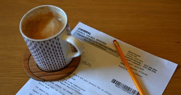 A council tax bill on a table next to a cup of coffee.