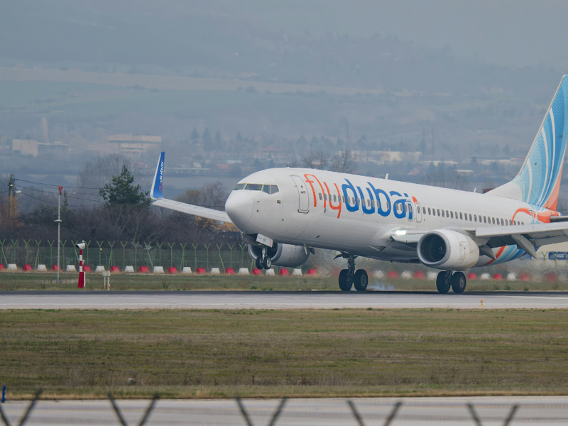 A Flydubai plane landing on a runway.