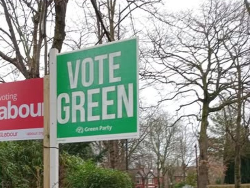 Signs for the Labour Party and the Green Party in Gorton and Denton