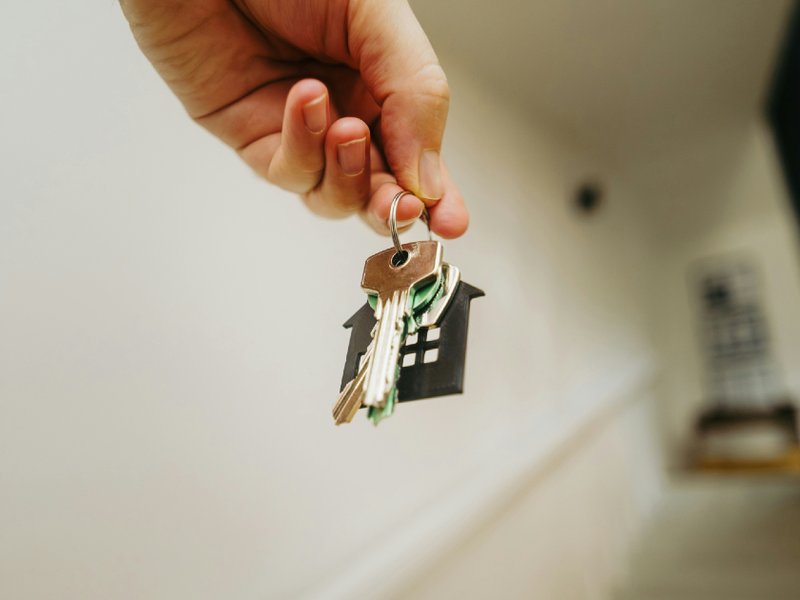 A picture of a person holding a house key in their hand.