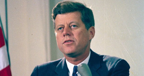 An image of President John F Kennedy delivering a radio and television address regarding the dismantling of Soviet missile bases in Cuba.