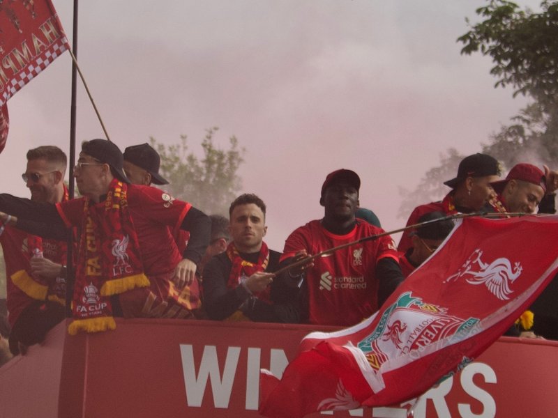 A photo of Liverpool FC players, including Diogo Jota, on the top deck of a red bus during the 2022 victory parade.