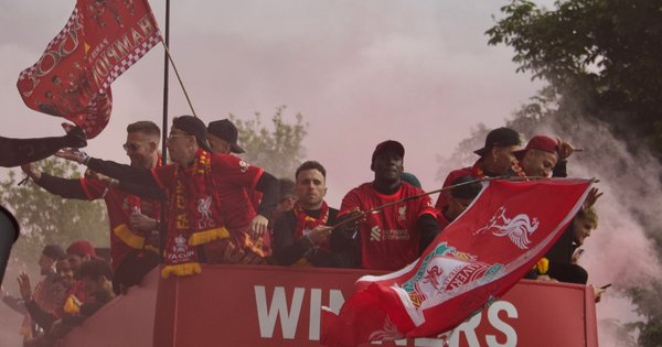 A photo of Liverpool FC players, including Diogo Jota, on the top deck of a red bus during the 2022 victory parade.