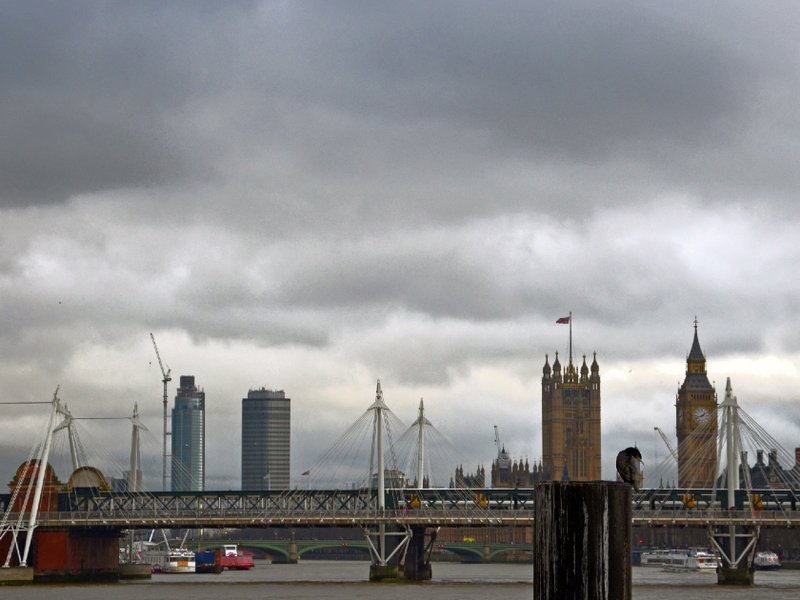A view of the London Eye, the Thames river and Parliament.
