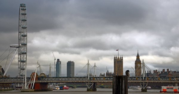 A view of the London Eye, the Thames river and Parliament.