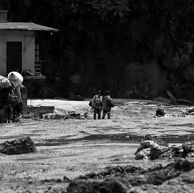 People carrying belongings through the aftermath of flash flooding in Nepal's Nuwakot district.