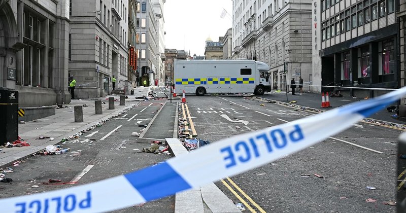 A photo of a police line and police van in the background