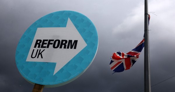 A placard with Reform UK’s logo on it with a Union Jack attached to a lamppost in the background.