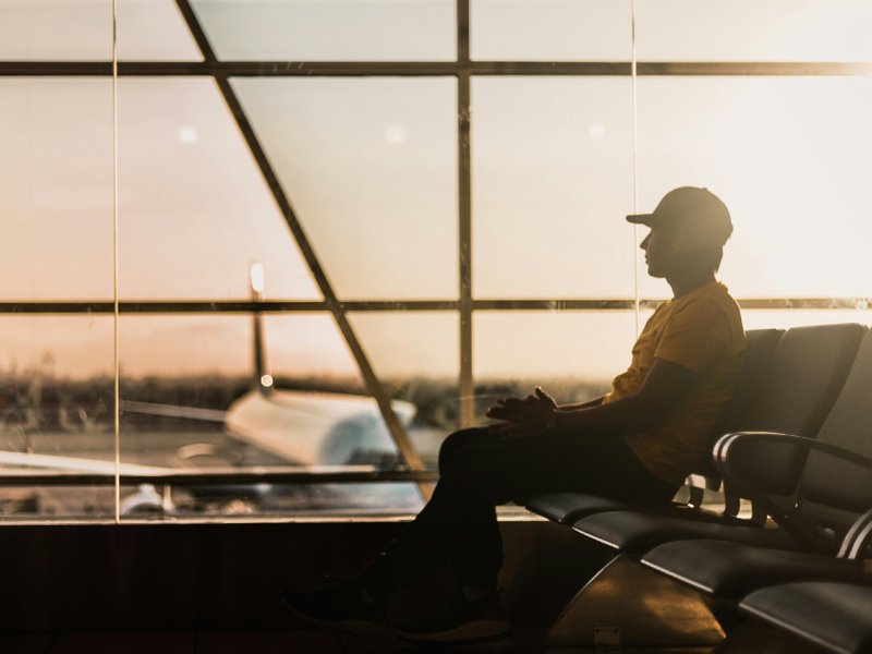 A photo of a man waiting in an airport terminal.