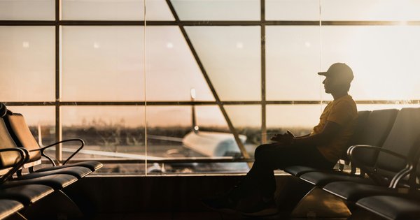 A photo of a man waiting in an airport terminal.