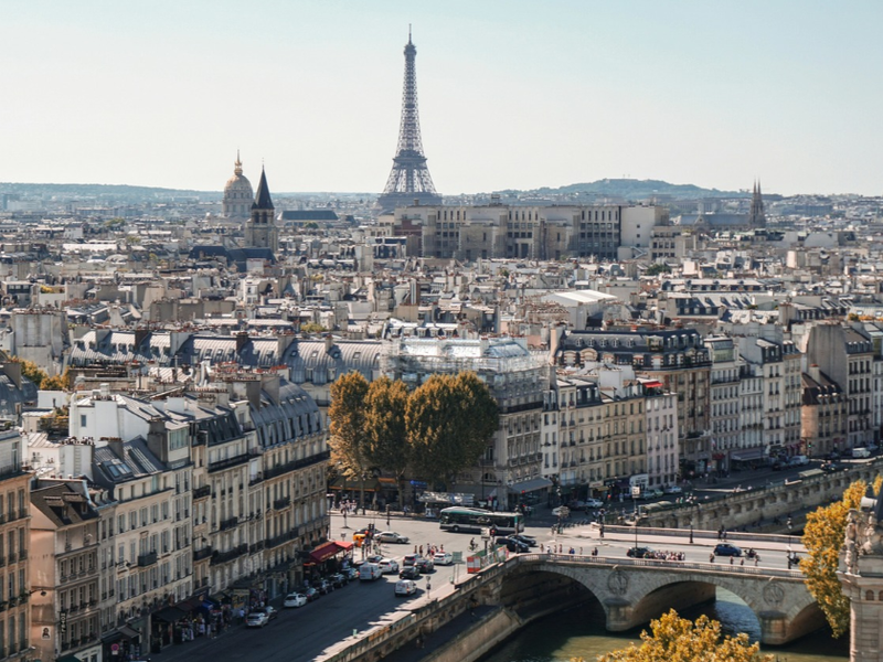 Photograph of buildings alongside the river in Paris, with the Eiffel Tower in the background
