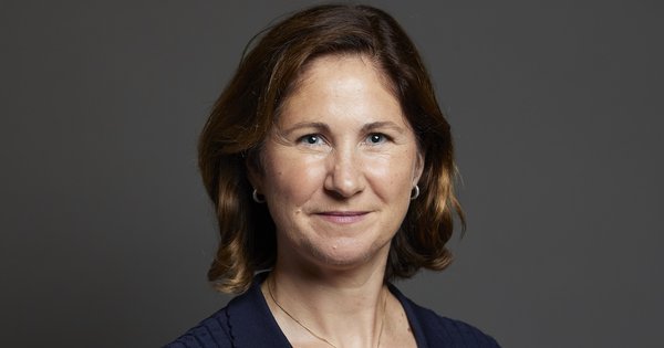 Parliamentary photo of Anna McMorrin, a brown-haired woman wearing a navy dress looking at the camera