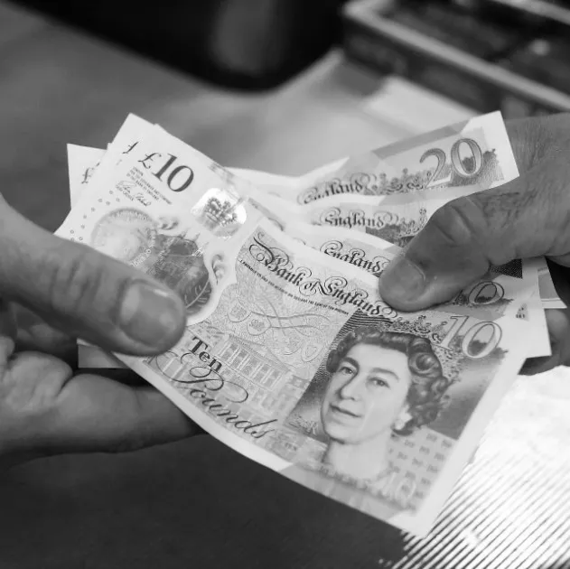 A person handing over some bank notes.