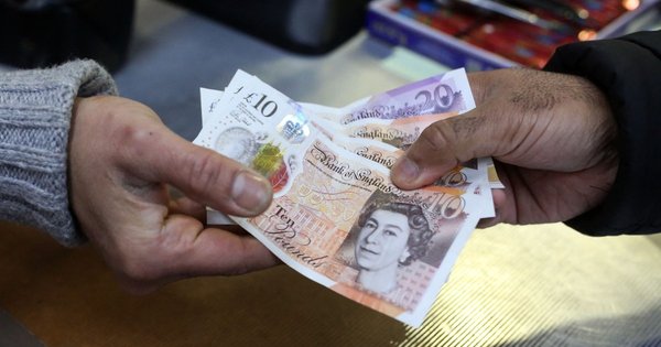 A person handing over some bank notes.