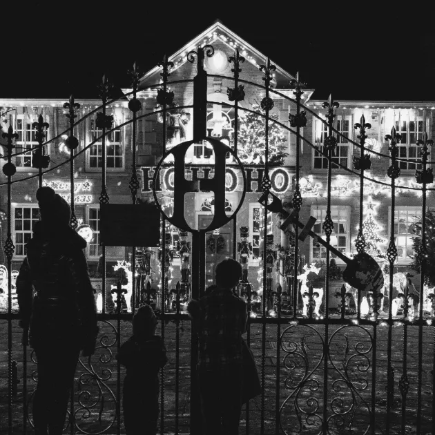A picture of a family visiting Christmas lights on a house in Sheffield, UK
