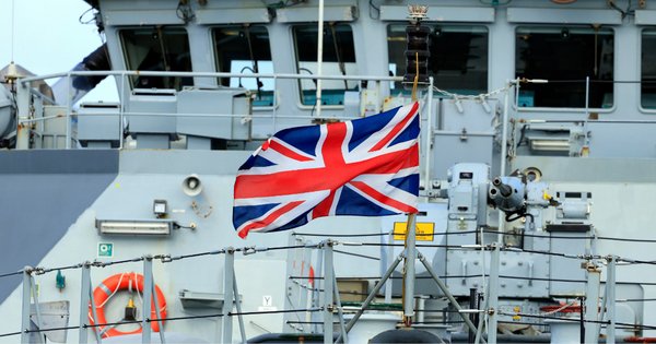 The Union Jack flying on the bow of the Royal Navy ship, HMS Tamar.