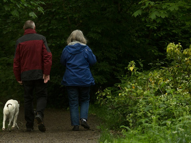 Retired couple walking their dog