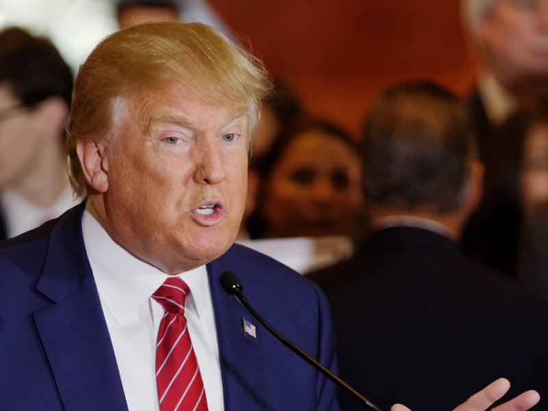 President Donald Trump speaking at a lectern with a microphone.