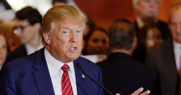 President Donald Trump speaking at a lectern with a microphone.