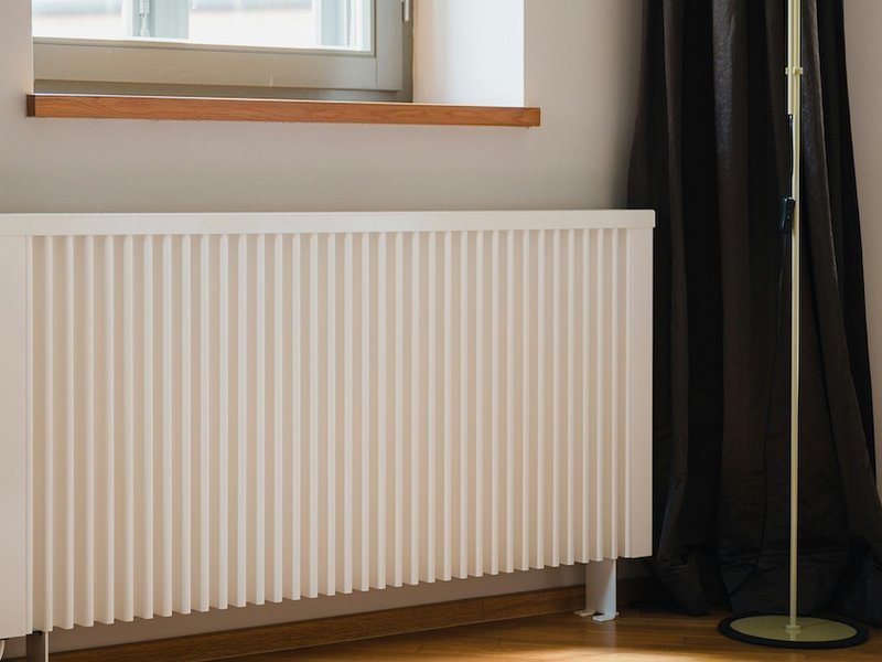 An electric heater in front of a window.