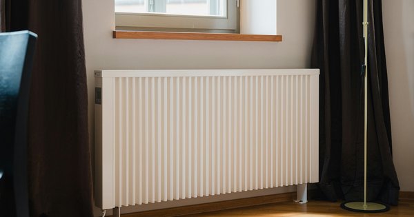 An electric heater in front of a window.