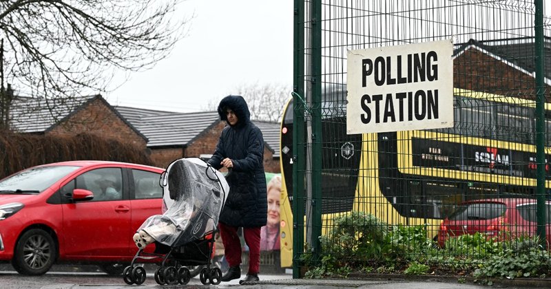 A woman with a pushchair outside a polling station in Gorton and Denton
