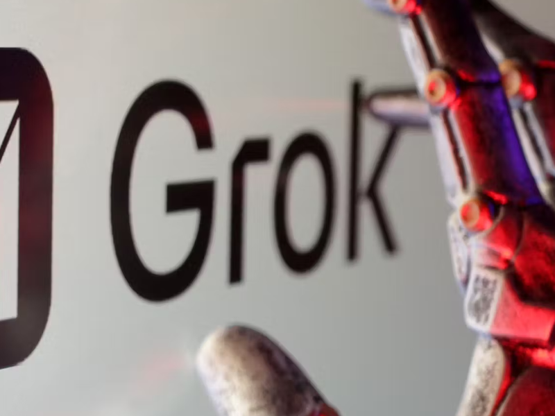 An image of the Grok AI logo with a robot hand in the foreground.
