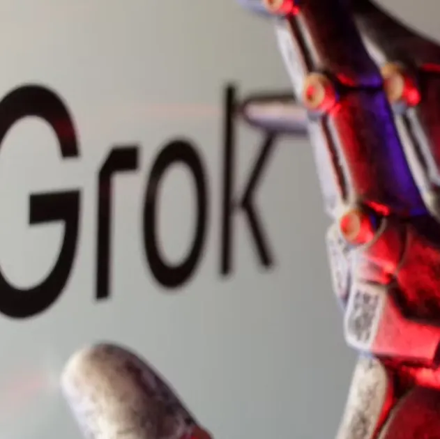 An image of the Grok AI logo with a robot hand in the foreground.